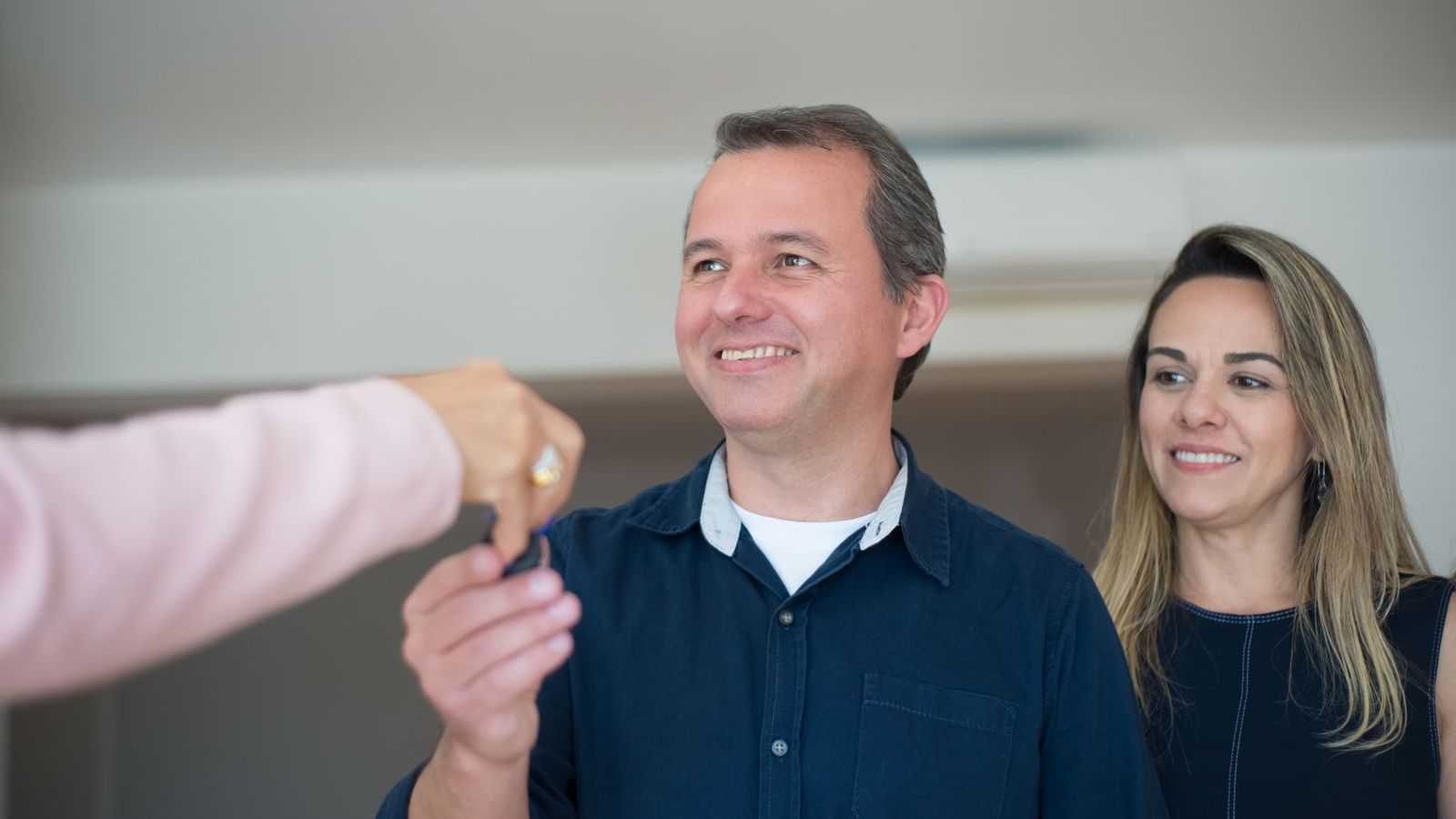Une remise de clés devant la porte d'un logement