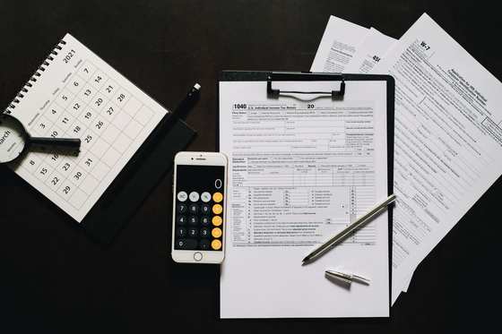 Un formulaire fiscal, une calculatrice et des documents sur un bureau