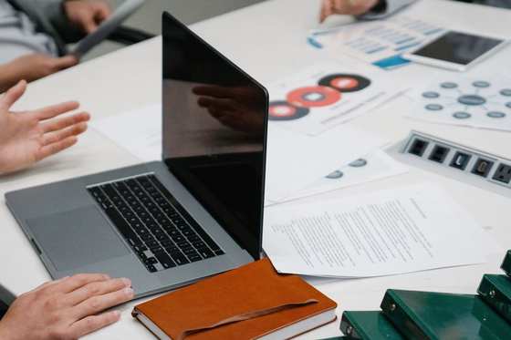 Une réunion de travail autour de dossiers et d'un ordinateur